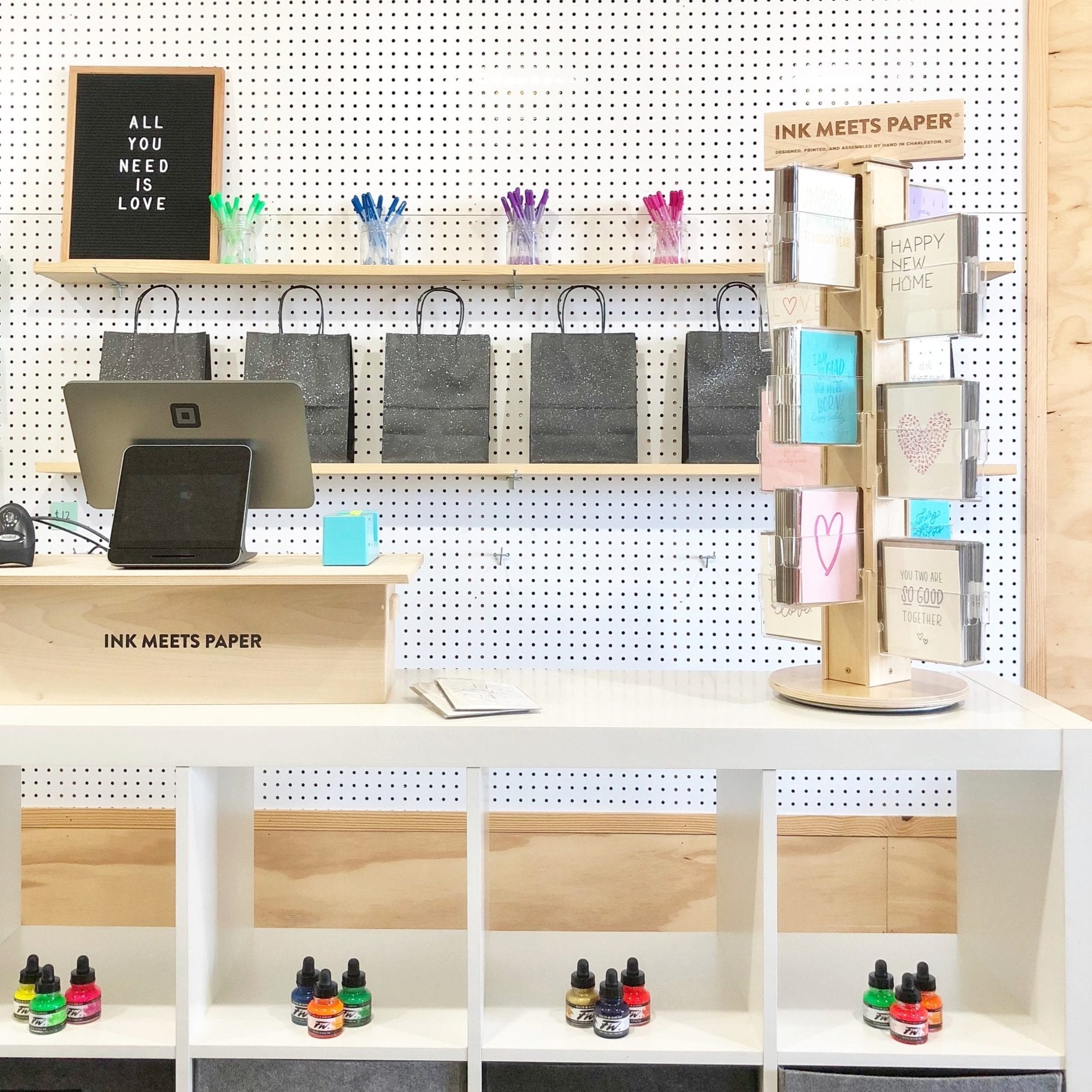 Retail Checkout Counter showing paper goods on display along with a point-of-purchase card spinner with company branding.