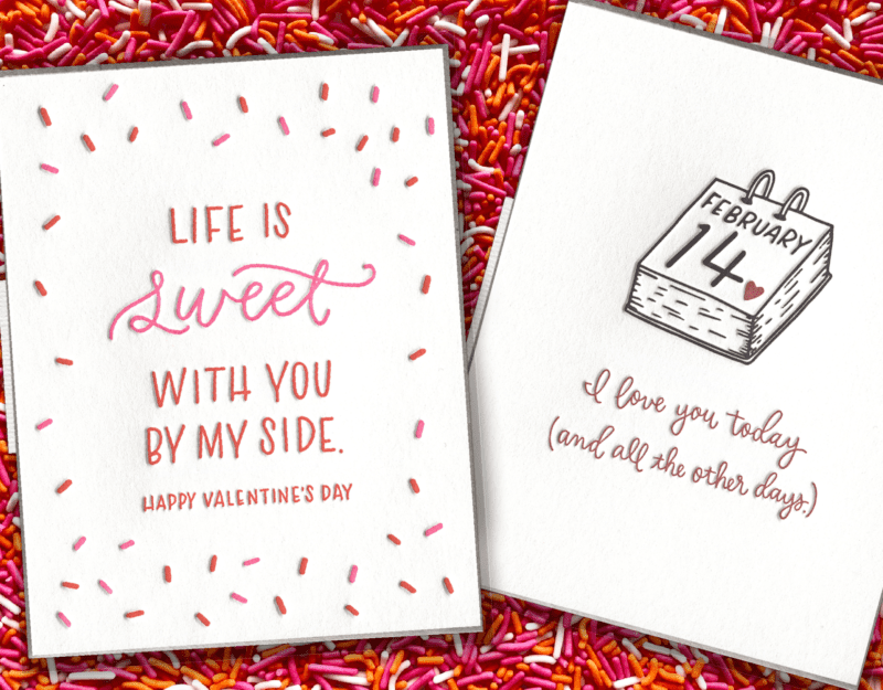 Colorful greeting cards over a colored-sprinkles background. Both are love themed for Valentine's Day.