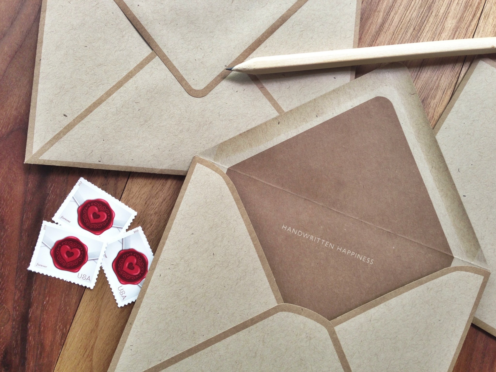 Brown kraft envelope is open and "handwritten happiness" is visible on the brown printed liner